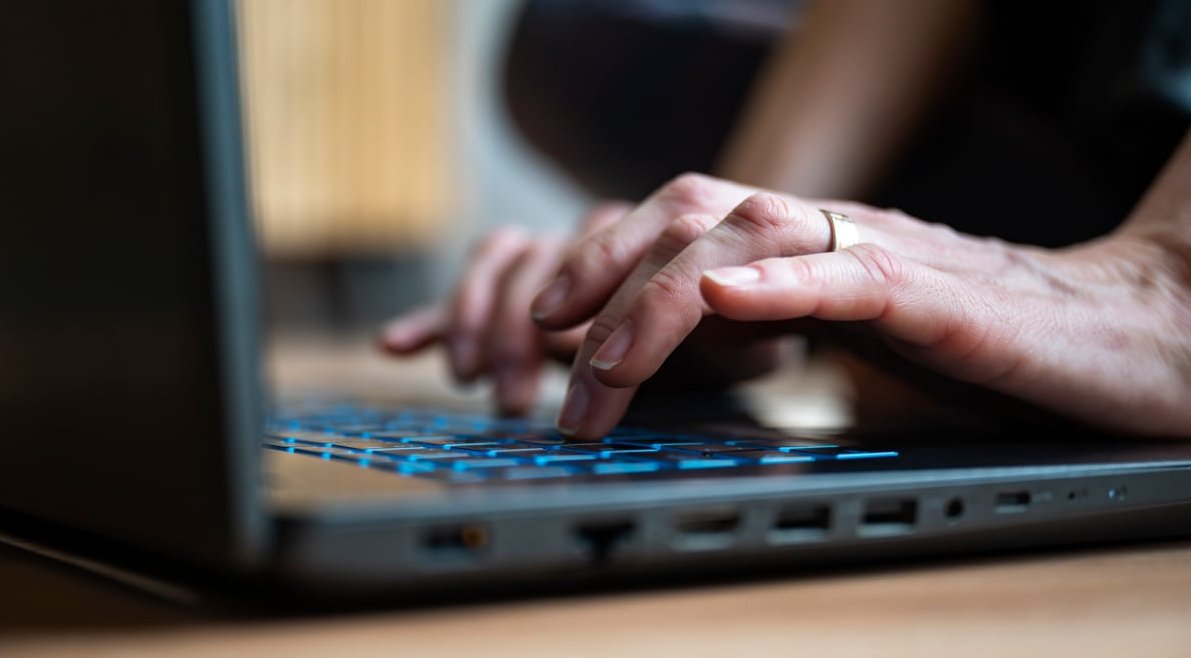 person typing ad on computer